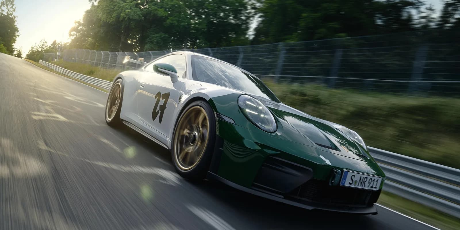 Porsche 911 GT3 100 Jahre Nürburgring, biały lakier z zieloną folią z przodu i numerem 27, ujęcie 3/4 z przodu na torze