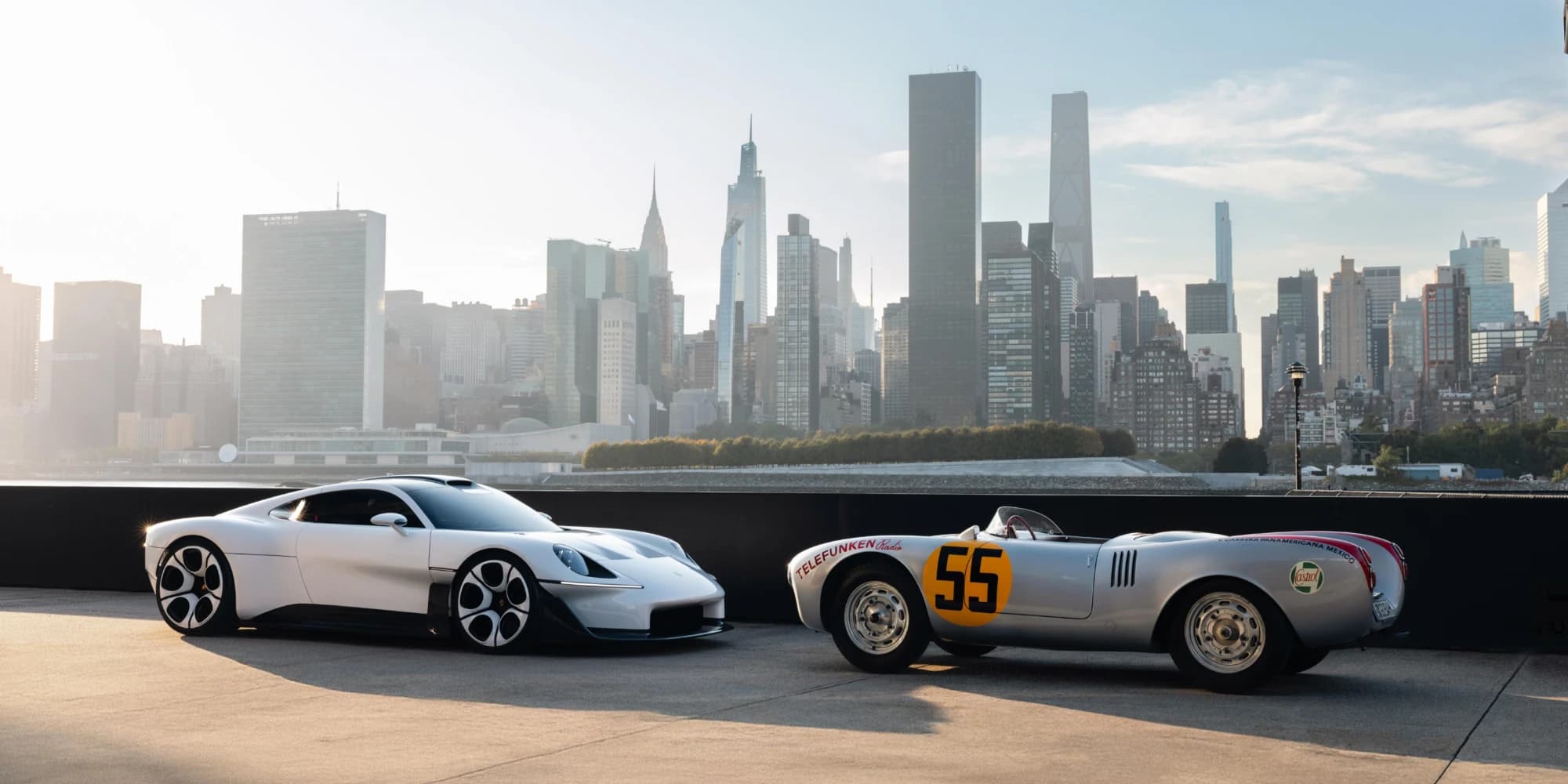 Porsche Mission S obok 550 Spyder z numerem 55 na pirsie w Queens, Manhattan w tle